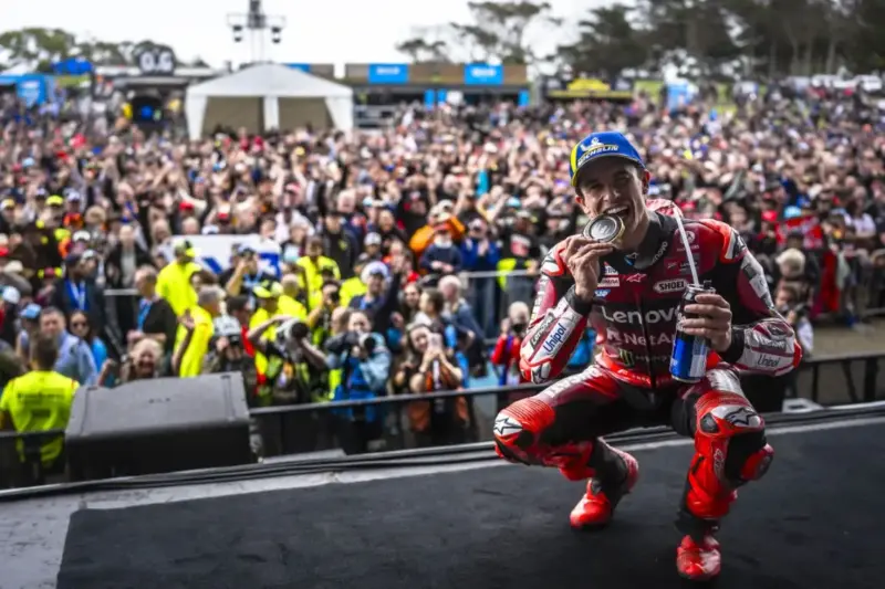 Marc Marquez in tuta Ducati bacia la medaglia sul palco davanti ai tifosi MotoGP